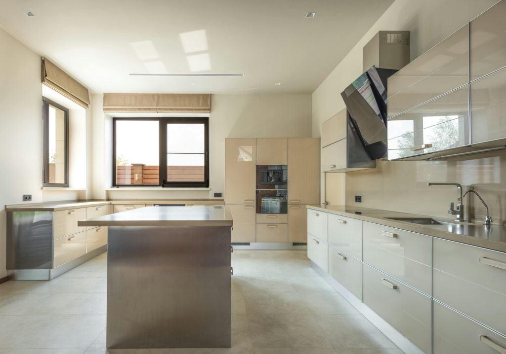 Helle und geräumige, moderne Küche mit eleganten Schränken und einer zentralen Kücheninsel.